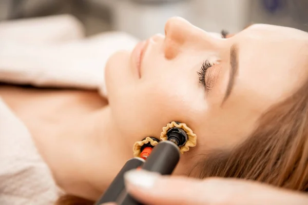 Mulher recebendo rosto pele cuidados rejuvenescimento com rf elevação aparelho elétrico salão de beleza profissional — Fotografia de Stock