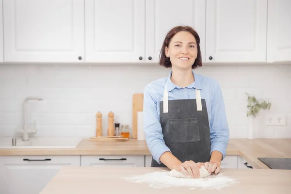 Mulher jovem dona de casa prepara massa no fundo da cozinha leve, pizza fresca — Fotografia de Stock