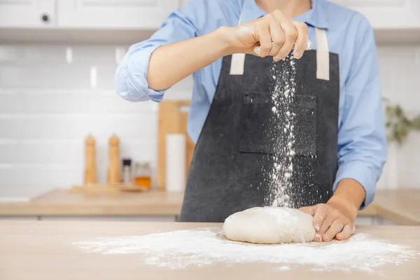 Padeiro chef mão polvilhando farinha massa fresca na mesa da cozinha, banner fundo branco — Fotografia de Stock