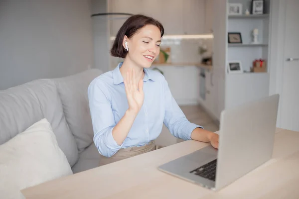 Gesture is begroeten, meisje zwaait haar hand hallo aan familieleden en vrienden werken aan internet video call — Stockfoto