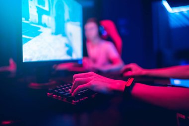 Profesyonel oyuncu selamlaması ve destek ekibi online oyunu neon rengi bulanık arka planda yumrukluyor. Yumuşak odak, arka görünüm