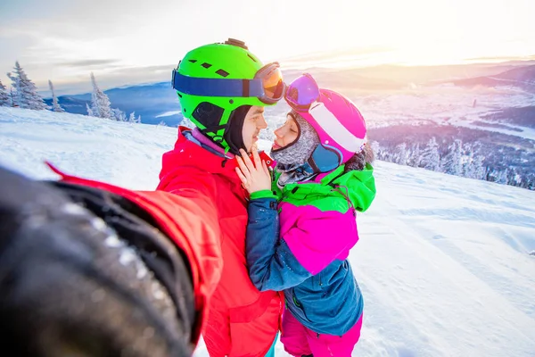 Selfie foto amante pareja snowboarder y esquiador de la mano en el fondo de las montañas en invierno, la luz del sol. Concepto estación de esquí — Foto de Stock