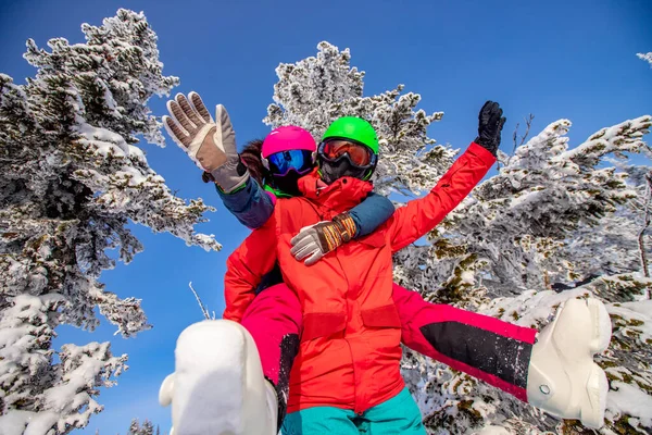 Amar pareja mujer y hombre divertirse y perder el tiempo en el bosque de invierno. Esquiador y snowboarder sobre fondo de cielo azul — Foto de Stock