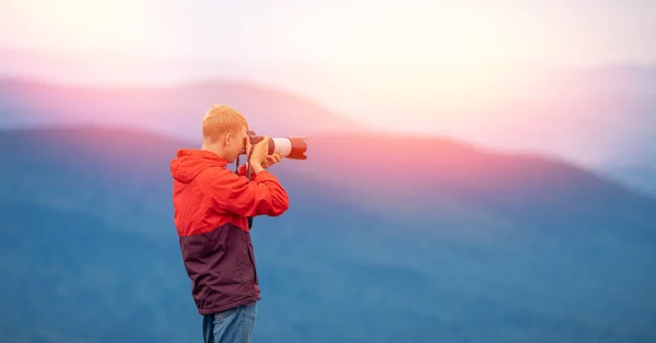 Fotograf podziwia zachody słońca, udane robienie zdjęć podczas podróży z aparatem fotograficznym, widok z tyłu — Zdjęcie stockowe