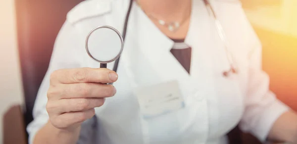 Mujer doctora sosteniendo un estetoscopio o fonendoscopio en el fondo de la bata médica blanca, preparándose para recibir al paciente —  Fotos de Stock