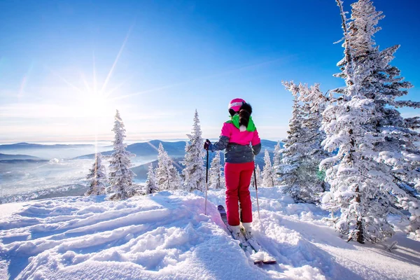 山の中で冬の休暇を楽しんで幸せな女性。森の中で雪と太陽と遊ぶ — ストック写真