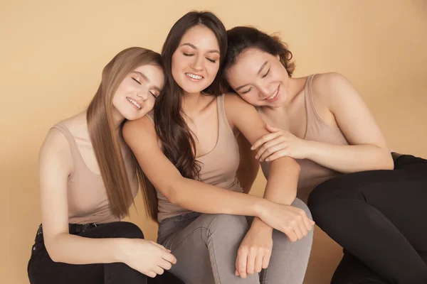 Gruppo multirazziale donne in piedi abbraccio e guardando la fotocamera. Amicizia in posa insieme asiatica, bionda, bruna — Foto Stock