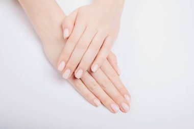 Modaya uygun genç bir kadın arka planda pembe manikür yapıyor. Cilt bakım kaplıcasını düşün