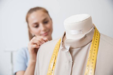 Terzi dikiş elbiseleri için kumaşa terzi iğnesi saplıyor.