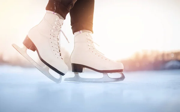 White figure skates on winter ice rink with blurry bokeh background
