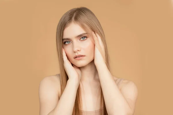 Hermoso retrato de mujer joven sobre fondo beige aislado, cuidado de la piel y el cabello concepto de cara de belleza —  Fotos de Stock