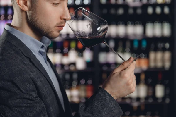 Vinmakare sommelier man sniffar doft rött vin i glas — Stockfoto