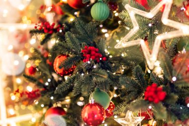 Bulanık arka plan ışıkları yıldız Noel ağacı kırmızı top oyuncakları, ışıklardan sarı bokeh