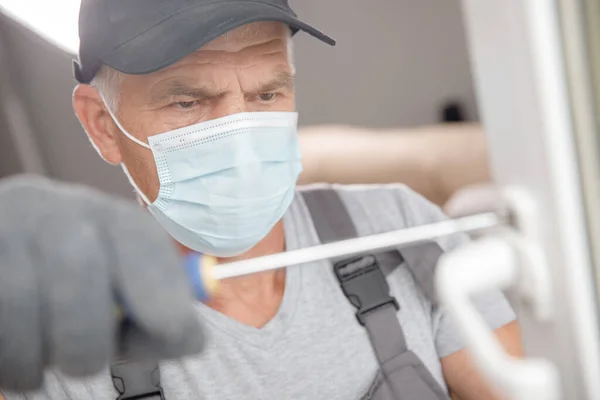 Worker man installs plastic windows and doors with double-glazed white