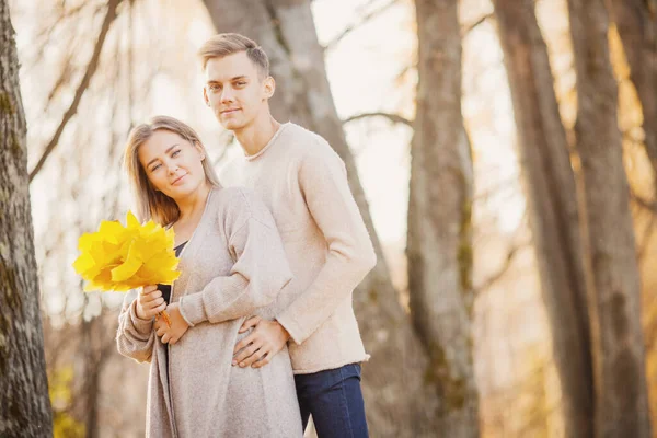 Liebendes Paar im Herbst Park mit Ahornblättern in den Händen von Mädchen, helles Licht — Stockfoto