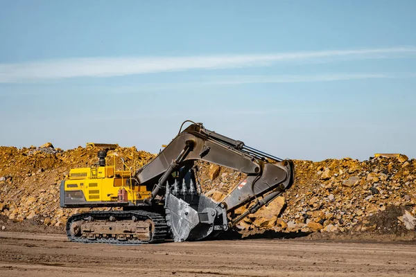 Cubo de acero de la excavadora amarilla que trabaja en la construcción mina abierta — Foto de Stock