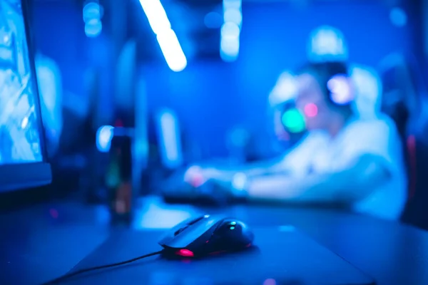 Selective focus on gaming computer mouse, in background video gamer participates in tournament stream — Stock Photo, Image