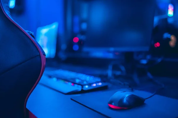 Professional cyber video gamer studio room with personal computer armchair, keyboard for stream in neon color blur background. Soft focus — Stock Photo, Image