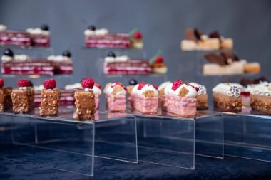 Tatlı tatlı masası yemek servisi ve düğün için çikolatalı browni ve siyah arka planda miskekler.