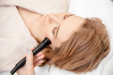 Kadın yüz bakımını yeniliyor. RF ile elektrikli aletleri kaldırıyor. Profesyonel güzellik salonu.