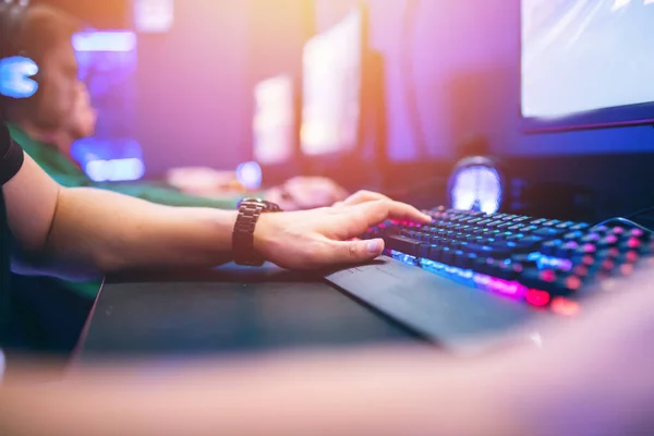 Sala de estudio profesional de videojuegos cibernéticos con sillón de computadora personal, teclado para flujo en fondo borroso de color neón. Enfoque suave —  Fotos de Stock