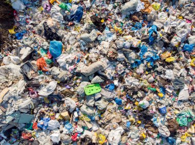 Plastik şişeler ve poşetlerle kara kirliliği. Katı atıkların depolandığı yeri aç. Havadan üst görünüm