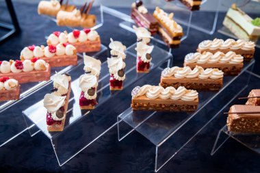 Tatlı tatlı masası yemek servisi ve düğün için çikolatalı browni ve siyah arka planda miskekler.