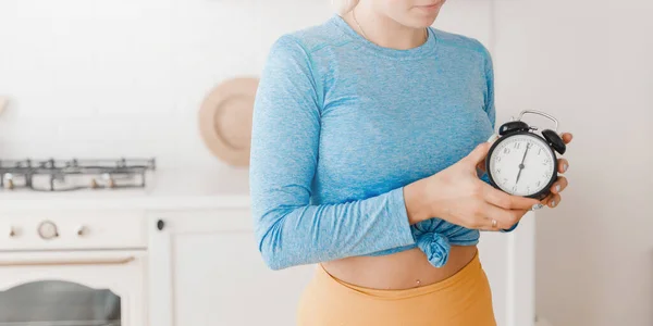 Mädchen in Sportbekleidung schlägt sechs Uhr morgens Alarm für frühes Fitnesstraining. — Stockfoto