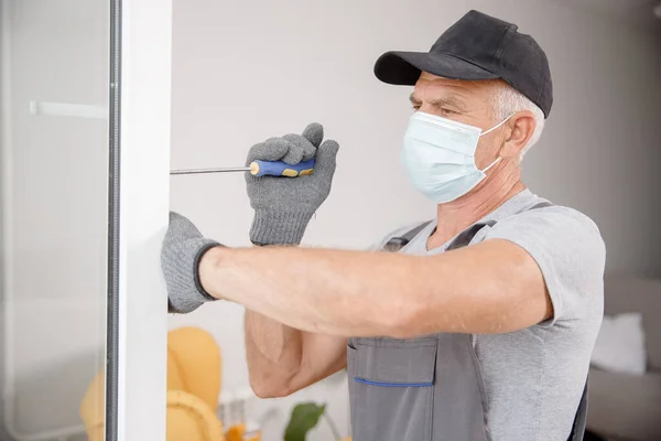 Trabalhador homem instala janelas de plástico e portas com vidro duplo branco — Fotografia de Stock