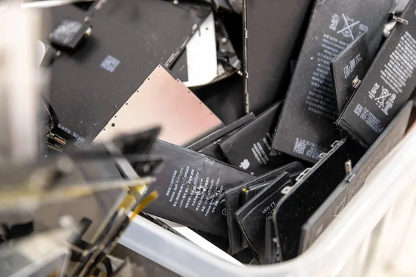 Сломанные экраны телефонов iPhone Apple и используемые аккумуляторы в ремонтной мастерской по переработке отходов, Россия - 27 июля 2020 г. — стоковое фото