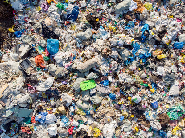 Загрязнение земли пластиковыми бутылками и пакетами. Открытое хранение твердых отходов. Вид сверху с воздуха