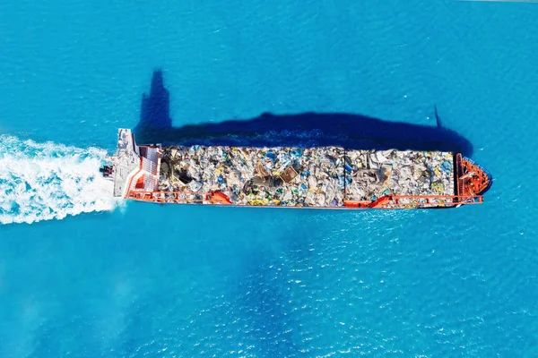 Lastfartyg transporterar containrar med skräp till återvinningsfabriken. Begreppet föroreningsmiljö och hav — Stockfoto