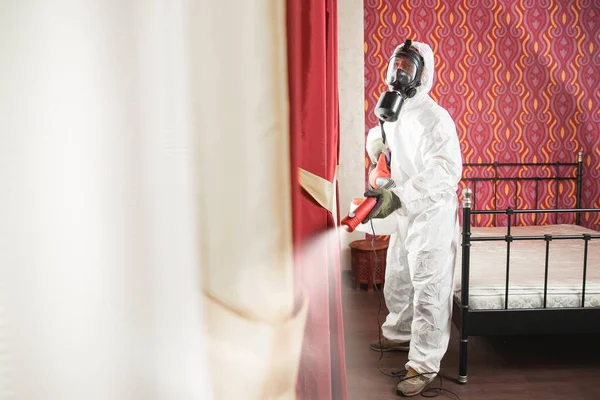消毒预防COVID-19，酒店内的危险工作服消毒专家。概念验尸官大流行病清楚 — 图库照片