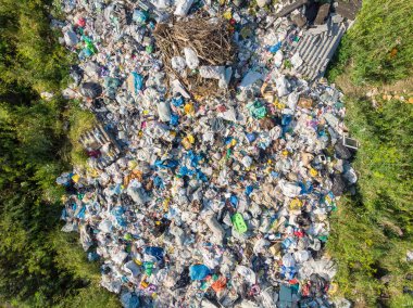 Plastik şişeler ve poşetlerle kara kirliliği. Katı atıkların depolandığı yeri aç. Havadan üst görünüm