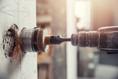 İnşaatçı, beton duvardaki elektrikli kovalamacayı çekiç, elmas kaplama ile kesiyor.