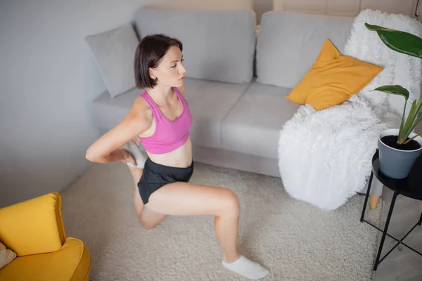 Evde vücut geliştirme eğitimi alan bir kız evde yoga yapıyor. Spor yaşam tarzı kavramı — Stok fotoğraf