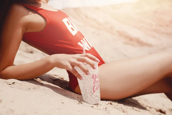 Ritratto di moda donna felice sulla spiaggia di sabbia vacanza, costume da bagno rosso bere cocktail. Copia spazio, ora legale — Foto Stock