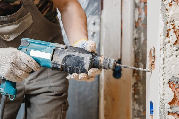 Operatore edile martello pneumatico trapani foro in muro di mattoni di cemento con corona di diamanti per cavo elettrico, presa, interruttore — Foto Stock