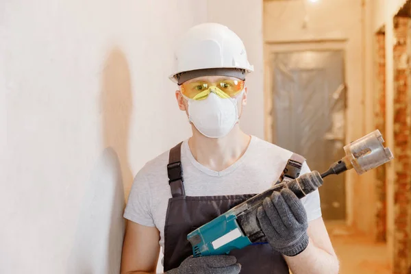 Homem trabalhador construtor faz foto selfie com óculos de segurança e capacete branco com brocas de martelo pneumático — Fotografia de Stock