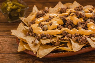 Nacho cips Mısır kıyma ile süslenmiş, plaka üzerinde ahşap masa Meksika baharatlı gıda Meksika beyaz peynir erimiş