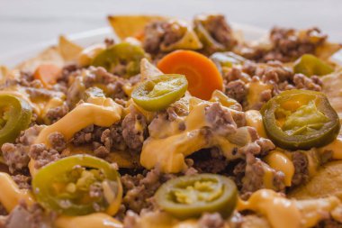 Nacho süslenmiş kıyma, eritilmiş peynir, biber plaka ahşap masa Meksika baharatlı gıda Meksika Mısır chips