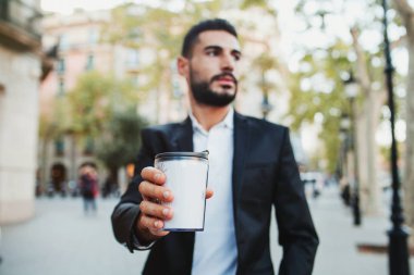 Genç adam bir kahve Kupası içki üzerine tutarak