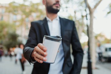 Genç adam bir kahve Kupası içki üzerine tutarak