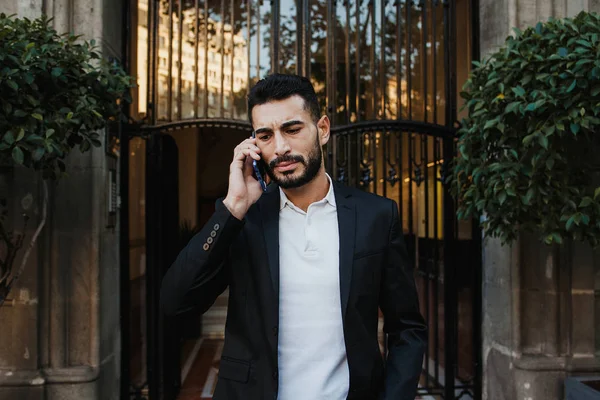 pensive young man talking on phone on the street