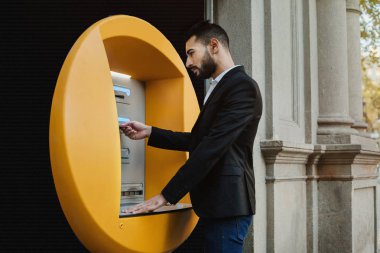 Genç adam nakit çekme ATM kullanarak