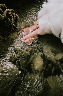 Bir nehir kaya, su yüzeye yakın ayakları üzerinde oturan kadın