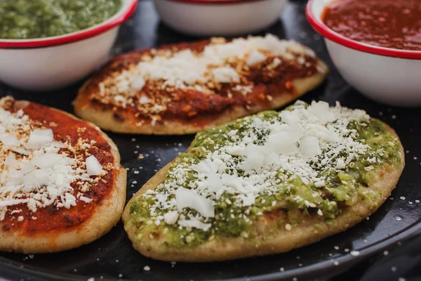 Tlacoyos mexicanos con salsa verde y roja, Comida tradicional en México —  Fotos de Stock