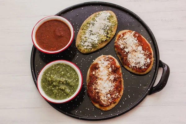 Mexikansk tlacoyos med grön och röd sås, traditionell mat i Mexiko — Stockfoto