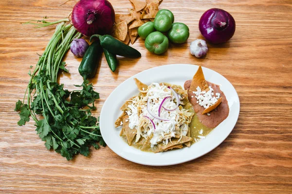 Chilaquiles verdes con pollo, comida mexicana, desayuno tradicional en México —  Fotos de Stock