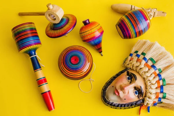 Sarı bir arka plan üzerinde Meksika'da Ahşap, balero, yoyo ve trompo meksika oyuncaklar — Stok fotoğraf